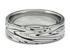 a silver ring with black and white swirls on the inside, in front of a white background