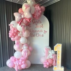 balloons are arranged in the shape of a arch for a first birthday party at a children's play area