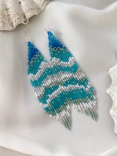 Thoughts about the ocean don't leave me, so I decided to create a piece of the waves for you. These exclusive ocean wave bead earrings are really good at vacation! Long blue and turquoise beaded earrings with sparkling beads remind you of the ocean breeze. It can be a cute gift for your loved ones. Also, you can complement your holiday look with these fringe earrings. ♡ Bead Length - 4.7'' (12 Centimeters) ♡ Total Length - 5.1'' (13 Centimeters) ♡ Width - M-size - 1.2'' (3 Centimeters) L-size - Ocean Beaded Earrings, Blue Round Beads With Beaded Fringe, Turquoise Earrings With Beaded Fringe For Beach, Turquoise Dangle Beaded Earrings With Tiny Beads, Handmade Blue Beaded Earrings For Beach, Turquoise Beaded Fringe Earrings For Summer, Turquoise Round Bead Earrings For The Beach, Handmade Turquoise Beaded Earrings For Beach, Turquoise Dangling Bead Drop Earrings