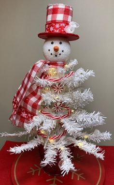 a white christmas tree with a snowman on top