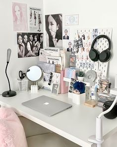 a white desk topped with a laptop computer and lots of clutter on top of it