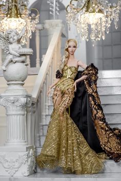 a barbie doll dressed in gold and black is standing on the stairs next to a chandelier