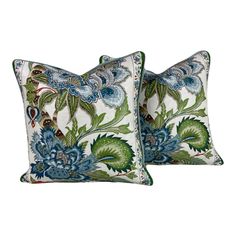 two pillows with blue and green floral designs on the front, one has a large flower pattern