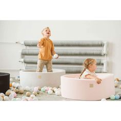 two young children playing in an egg carton