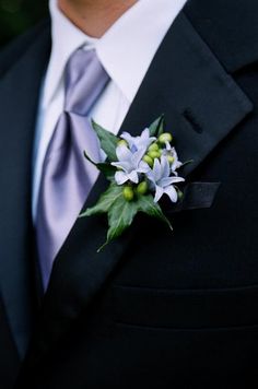 a man in a suit and tie with a boutonniere on his lapel