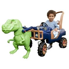 a little boy riding in a toy dinosaur car