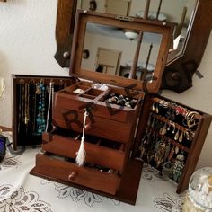 a wooden jewelry box sitting on top of a table next to a mirror and other items