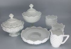 a group of white glass dishes and cups