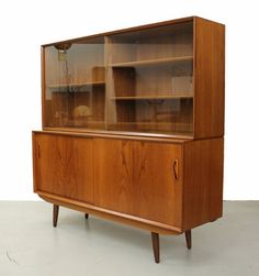 a wooden cabinet with glass doors and shelves