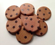 several wooden buttons are arranged on a white surface with holes in the middle and one has black dots