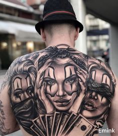 a man with tattoos on his back has money in front of him and is wearing a hat