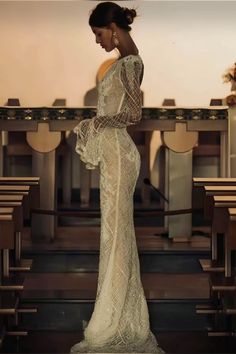 a woman in a white dress standing next to some pews