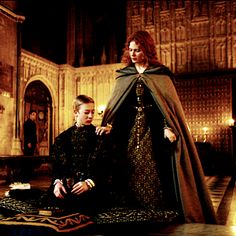 two people dressed in medieval clothing sitting on the floor