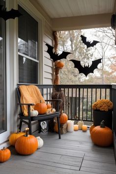 a porch decorated for halloween with pumpkins and bats