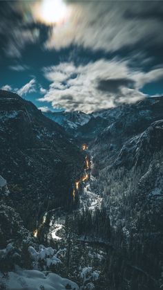 the mountains are covered in snow and lit up by lights from cars on each side