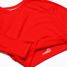 Fall in love with this versatile piece of eye-catching activewear. Our eco-friendly always bright red cropped rash guard –made with recycled polyester and elastane– is the perfect choice for swimming, sports, or athleisure outfits. The long sleeves and cropped cut provides just enough coverage while the UPF 50+ rated material helps block the sun’s harsh UV rays. Stand out in confidence and comfort all year long in our “wear anywhere” cropped top. .: Made with 81% REPREVE recycled polyester, 19% Sporty Red Cropped Tops, Red Moisture-wicking Long-sleeved Activewear, Functional Red Crew Neck Top, Sporty Fitted Red Crop Top, Red Fitted Sporty Crop Top, Functional Red Activewear For Summer, Red Sportswear Tops For Summer, Sporty Red Fitted Crop Top, Red Sporty Crop Top