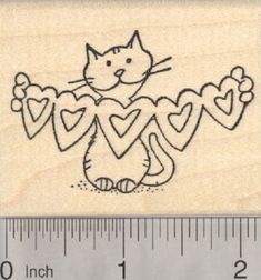 a rubber stamp with a cat holding hearts