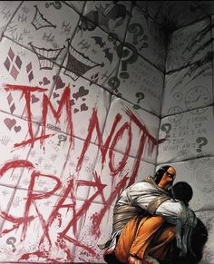 a man kneeling down next to a wall covered in graffiti