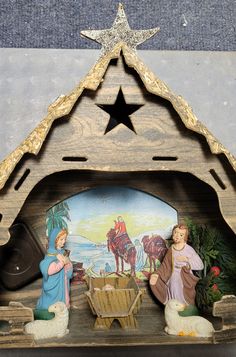 a wooden nativity scene with two figures and a star on the top of it