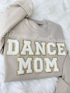 a sweatshirt with the words dance mom on it sitting on top of a furry surface