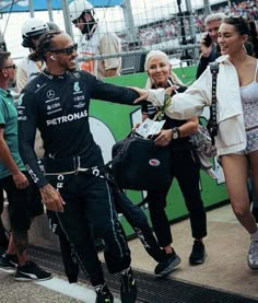 the man is shaking hands with two other people in front of an audience at a sporting event