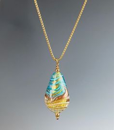 Handcrafted by skilled artisans in the heart of Venice, Italy, this glass bead is made from the finest Murano glass, known for its exceptional quality and unique beauty. Each piece is one-of-a-kind, featuring delicate swirls of color and intricate details that catch the light and shimmer with every movement. The elegant teardrop shape of this pendant adds a touch of sophistication to any outfit, whether you're dressing up for a special occasion or simply adding a pop of color to your everyday lo Teardrop Glass Beads For Jewelry Making, Handmade Teardrop Glass Jewelry, Handmade Glass Teardrop Pendant Jewelry, Yellow Murano Glass Jewelry Gift, Artisan Gold Glass Necklace, Glass Teardrop Pendant Necklace For Gift, Elegant Glass Teardrop Pendant Jewelry, Artistic Yellow Teardrop Jewelry, Handmade Czech Glass Teardrop Necklaces