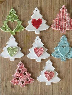 decorated christmas trees are displayed on a wooden table