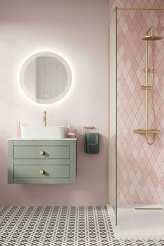 a bathroom with pink walls and white tiles on the floor, gold faucet