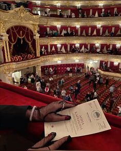 a person holding up a piece of paper in front of an auditorium