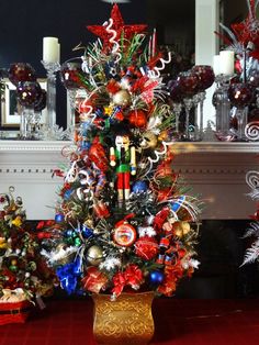 a decorated christmas tree sitting in front of a fire place with candles and ornaments around it