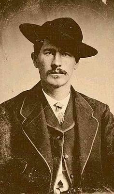 an old black and white photo of a man with a mustache wearing a suit and hat