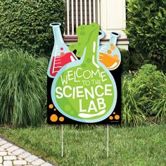 a welcome to the science lab yard sign in front of some grass and bushes with plants