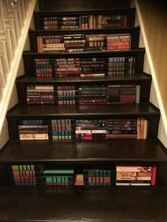 there is a set of stairs with books on the top and bottom shelves below it