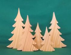 three wooden christmas trees on a green background