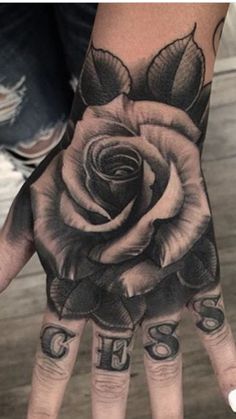 a person's hand with tattoos on it and a rose tattooed on the palm