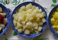 three bowls filled with different types of food on top of a floral tablecloth covered table