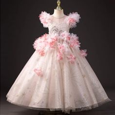 Expertly crafted for a perfect fit and elegant look, the Dreamy Vow Pink Girl Dress features intricate beading, 3D flowers, and delicate pearls. A stunning choice for weddings, birthday parties, and communions, this Arabic princess-inspired gown will make your little one feel like royalty. Princess Style Floral Applique Ball Gown For Wedding, Organza Ball Gown With Floral Applique For Debutante Ball, Princess Style Wedding Ball Gown With Floral Applique, Tulle Ball Gown With Floral Applique For Wedding, Wedding Tulle Dress With 3d Flowers, Wedding Dress With 3d Flowers In Tulle, Wedding Dresses With 3d Flowers And Tulle, Tulle Princess Dress With Floral Applique For First Communion, Princess Dress With Floral Applique For Debutante Ball