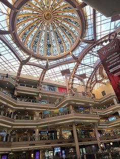 the inside of a shopping mall filled with lots of windows and people walking around it