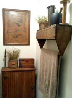 an old wooden cabinet with towels hanging from it's sides and a painting on the wall