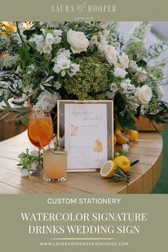 a table topped with flowers and drinks next to a sign that reads, custom stationery watercolor signature drinks wedding sign