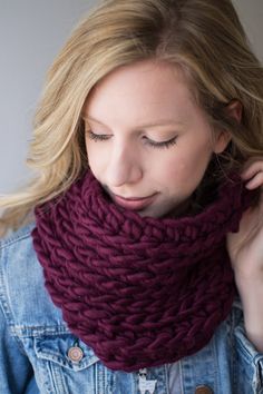 a woman wearing a purple scarf and denim jacket