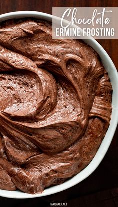 chocolate frosting is in a white bowl on a wooden countertop. Heritage Frosting Recipe, Ermine Frosting Chocolate, Ermine Frosting Flavors, Ermine Icing Recipe, Chocolate Almond Frosting, Chocolate Ermine Buttercream, Cream Cheese Ermine Frosting, Not So Sweet Chocolate Frosting, Chocolate Ermine Frosting Recipes