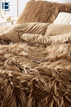 a bed covered in brown fur and pillows