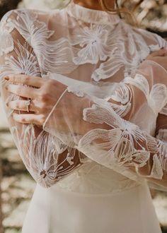 a close up of a person wearing a wedding dress and holding her hands on her chest