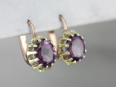 These unique earrings are the perfect balance of classic and modern! Amethyst sparkles with notes of mauve and lilac, contrasting beautifully with the green gold setting and rose gold findings.Metal: 14K Green and Rose GoldGem: 2 Amethyst totaling 5.25 CaratsGem Measurements: 8 x 10 mm, OvalEarrings Length: 18 mmEarrings Width: 11 mmMarks: "585" Stamped on the Findings Oval Earrings, Cameo Ring, Oval Earring, Ruby Jewelry, July Birthstone, Gold Drop Earrings, Gold Set, Hand Engraving, Eternity Bands