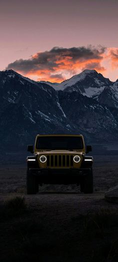 a jeep is parked in the desert with mountains in the background