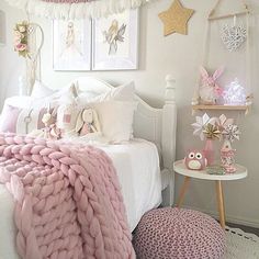 a white bed topped with pink blankets and pillows