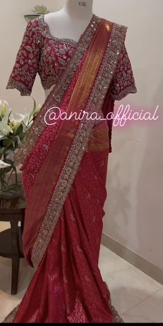 a red and gold sari is displayed in front of a mannequin's head