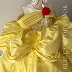 a yellow dress with a red rose on the back