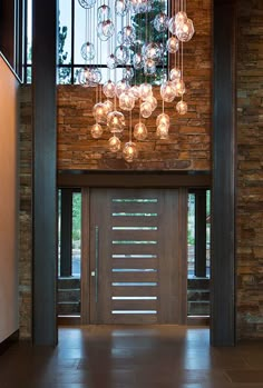 an entry way with glass balls hanging from the ceiling and brick wall in the background